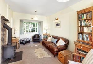 a living room with a couch and a fireplace at Coachman's Cottage, West Porlock in Porlock
