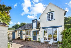 an exterior view of a white house with blue doors at Coachman's Cottage, West Porlock in Porlock