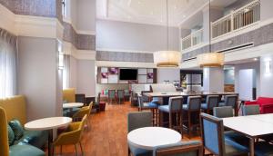 a restaurant with tables and chairs and a bar at Hampton Inn & Suites-Atlanta Airport North-I-85 in Atlanta