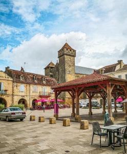 un gran edificio de piedra con un pabellón en un patio en Claire fontaine en Beaumont-du-Périgord