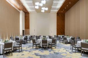 - une salle de banquet avec des tables et des chaises blanches dans l'établissement Hilton Mexico City Santa Fe, à Mexico