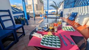 - une table avec de la nourriture et des boissons sur un balcon dans l'établissement La Maison Du Vent, à Essaouira
