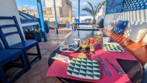 a table with food and drinks on a balcony at La Maison Du Vent in Essaouira