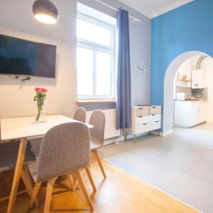 a dining room with blue walls and a table and chairs at Smart Old Town Apartment in Krakow