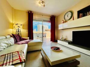 a living room with a couch and a clock on the wall at El Horno in Adeje