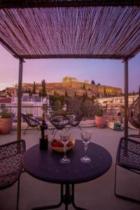 una mesa con dos copas de vino en un patio en Thalia by Heloni Apartments, en Atenas