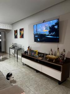 uma sala de estar com uma televisão de ecrã plano na parede em Casa Caruaru em Caruaru