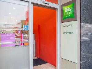 una porta arancione in un negozio con un cartello di Ibis Styles Invercargill a Invercargill