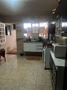 uma cozinha com electrodomésticos brancos e piso em azulejo em Casa Caruaru em Caruaru