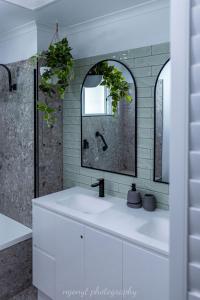 Baño blanco con lavabo y espejo en Large Noosaville Gem - Off Gympie Terrace, en Noosaville