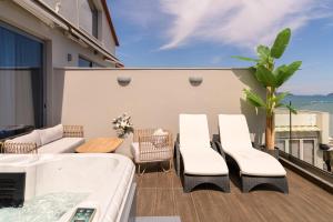 a balcony with a hot tub and a table and chairs at Pearl Luxury Living in Laganas