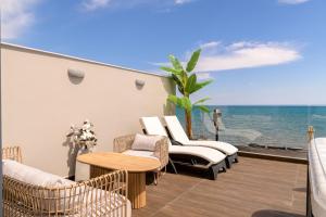 uma varanda com cadeiras e uma mesa e vista para o oceano em Pearl Luxury Living em Laganas