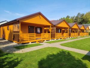 a row of wooden cabins in a row at Ośrodek wypoczynkowy nad morzem SEMI in Wicie