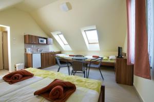 a room with two beds and a kitchen with a table at Penzion Admirál in Třeboň