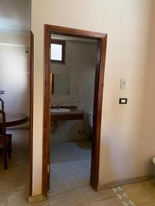 a doorway to a bathroom with a sink and a mirror at Villa Elhag Nile View in Luxor
