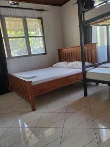 1 dormitorio con litera y 2 ventanas en The Nest Haven Hostel, en Dar es Salaam