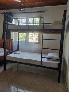 Ce dortoir comprend 2 lits superposés et une fenêtre. dans l'établissement The Nest Haven Hostel, à Dar es Salaam