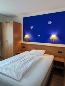 a bedroom with a large bed with a blue wall at Sonnenhof in Katlenburg-Lindau