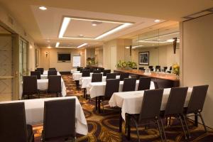 una sala de conferencias con mesas blancas y sillas negras en Hotel De Anza, a Destination by Hyatt Hotel en San José