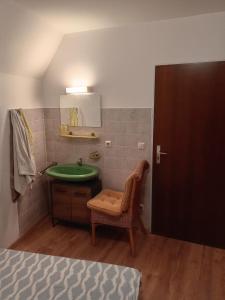 een badkamer met een wastafel, een stoel en een spiegel bij Hostel Alegria-Jumbo in Erlangen