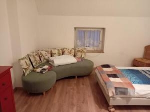 een woonkamer met een bank en een bed bij Hostel Alegria-Jumbo in Erlangen