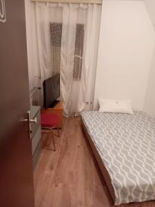 een kleine slaapkamer met een bed en een raam bij Hostel Alegria-Jumbo in Erlangen