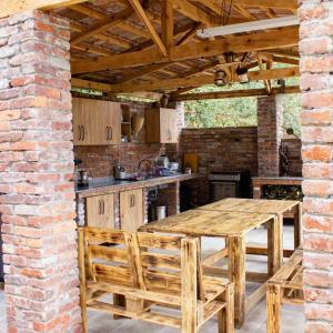 una cocina al aire libre con mesa de madera y sillas en BikePost AIR Georgia, en Zeda Dagva