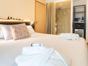 sypialnia z dużym białym łóżkiem z ręcznikami w obiekcie Mercure Avignon Gare TGV w Awinionie