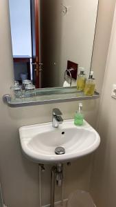 - białą umywalkę w łazience z lustrem w obiekcie Skipalaekur Guesthouse w mieście Egilsstaðir