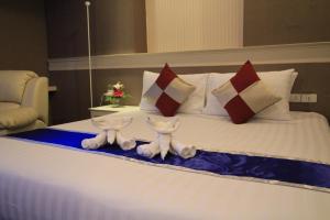 um quarto de hotel com uma cama com almofadas em โรงแรมวีวิช V Wish Hotel em Khon Kaen