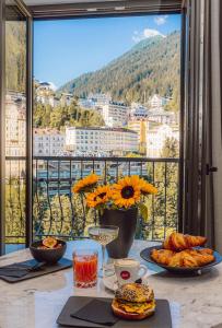 einen Tisch mit Speisen und Stadtblick in der Unterkunft Residenz Boutique Suites in Bad Gastein