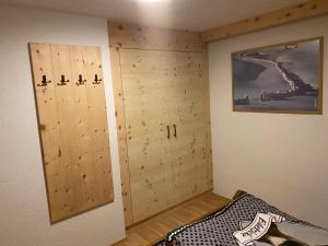 a room with wooden lockers in a room with a wall at Alpenfarm Poschhof in Kaunerberg