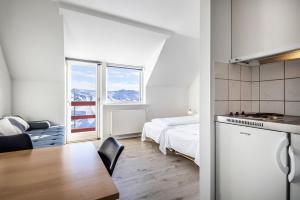 イルリサットにあるHOTEL SØMA Ilulissatのベッドルーム1室(ベッド1台付)、キッチン(テーブル付)