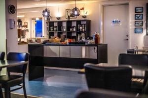 a kitchen with a counter and chairs in a restaurant at HOTEL SØMA Ilulissat in Ilulissat