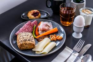 a plate of food with meat and vegetables on a table at HOTEL SØMA Ilulissat in Ilulissat