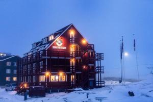 a large building in the snow at night at HOTEL SØMA Ilulissat in Ilulissat