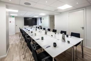 a conference room with a long table and chairs at HOTEL SØMA Ilulissat in Ilulissat