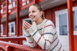 a woman in a sweater looking at her cell phone at HOTEL SØMA Ilulissat in Ilulissat