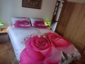 sypialnia z łóżkiem z różowymi różami w obiekcie Casa Bozzero w mieście Krnica