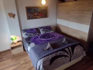 a bedroom with a bed with a purple blanket on it at Casa Bozzero in Krnica +81 photos