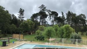 a swimming pool in a yard with trees in the background at Casas da Ladeia - Villa 2 in Alvorge