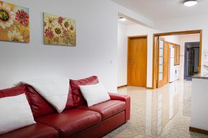 un soggiorno con divano in pelle rossa in una camera di Maria Benta House a Ribeira Grande
