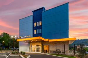 a glass building with a sunset in the background at Comfort Suites Gatlinburg Downtown-Convention Center in Gatlinburg