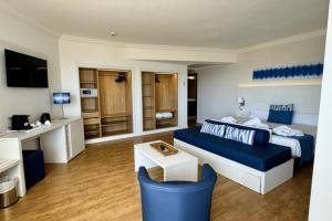 une chambre d'hôtel avec un lit et un canapé bleu dans l'établissement Cabot Pollensa Park Spa, à Port de Pollença