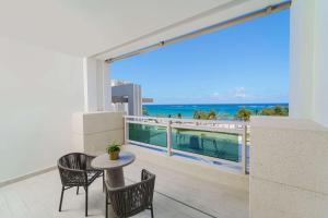 a balcony with a table and chairs and a view of the ocean at Wyndham Grand Barbados Sam Lords Castle All Inclusive Resort in Saint Philip