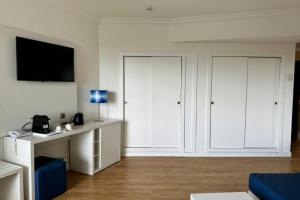 a living room with white cabinets and a television at Cabot Pollensa Park Spa in Port de Pollensa