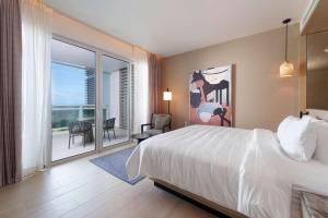 a hotel room with a bed and a balcony at Wyndham Grand Barbados Sam Lords Castle All Inclusive Resort in Saint Philip
