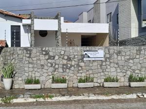 a stone retaining wall with plants on it at Conceitual Hostel Natal in Natal
