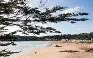 uma vista para uma praia com pessoas na água em L’Horizon Beach Hotel & Spa em St Brelade