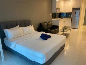 um quarto com uma cama com uma toalha azul em Mercu Summer Suite by Great Service em Kuala Lumpur